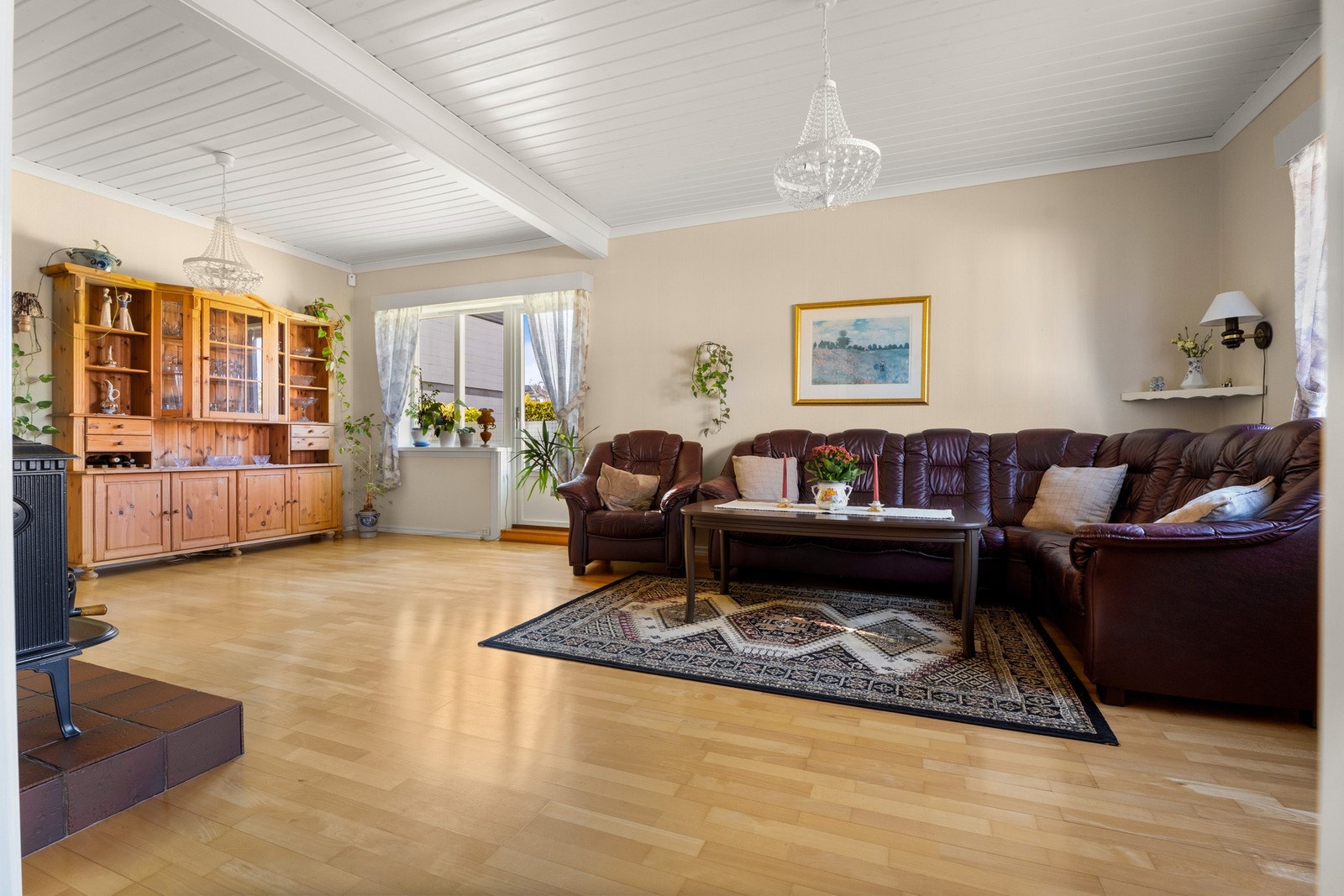 Parkettgulv og panel i taket gir stuen et lunt og innbydende uttrykk. Galleribilde