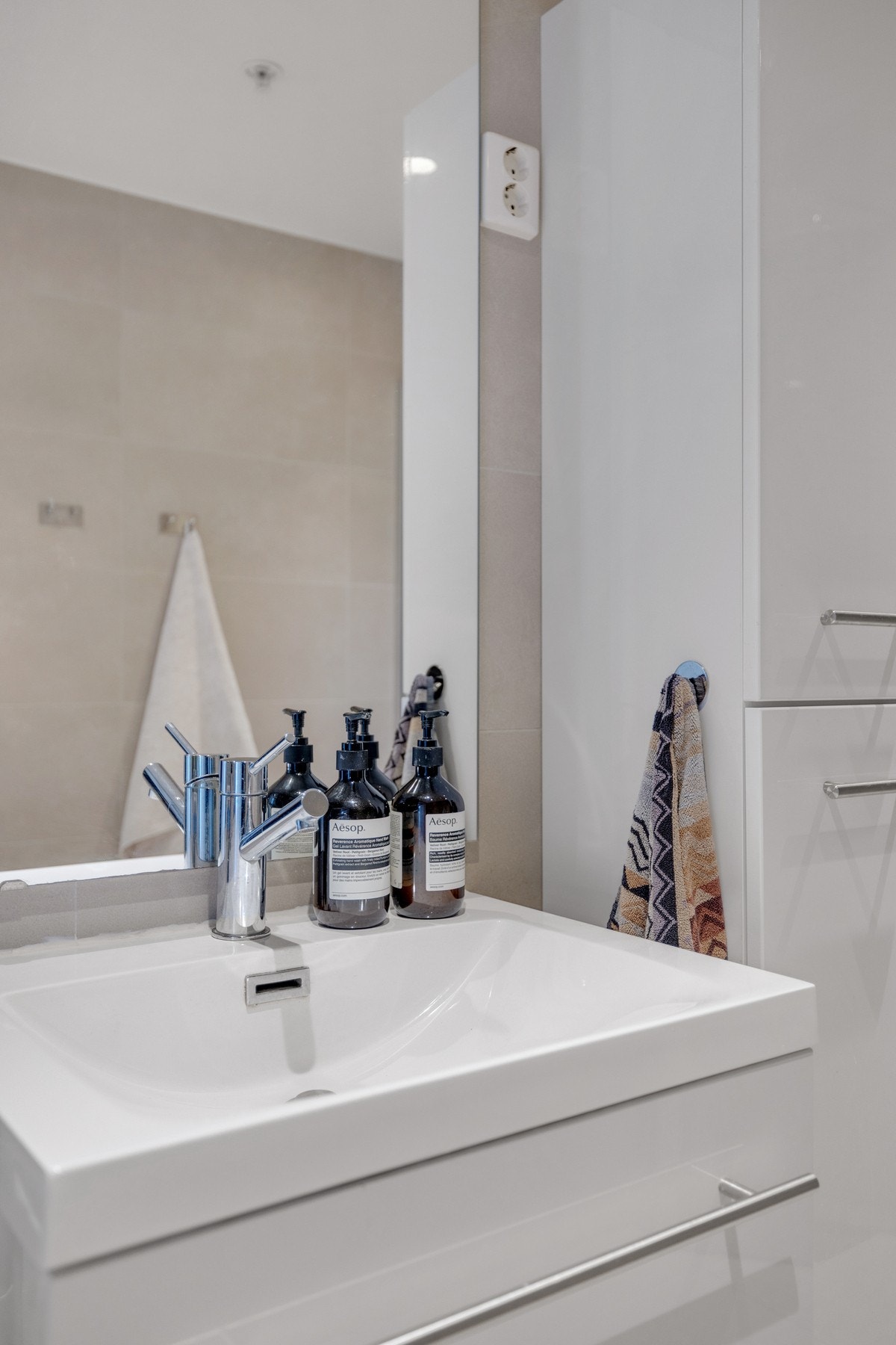 Moderne servant på vegghengt servantskap og praktisk vegghengt skap for oppbevaring av håndklær og diverse. Galleribilde