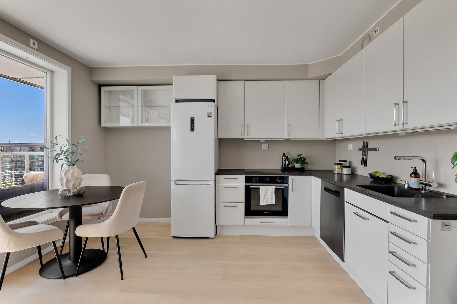 Stilrent kjøkken med hvite glatte fronter og praktisk utforming. Galleribilde