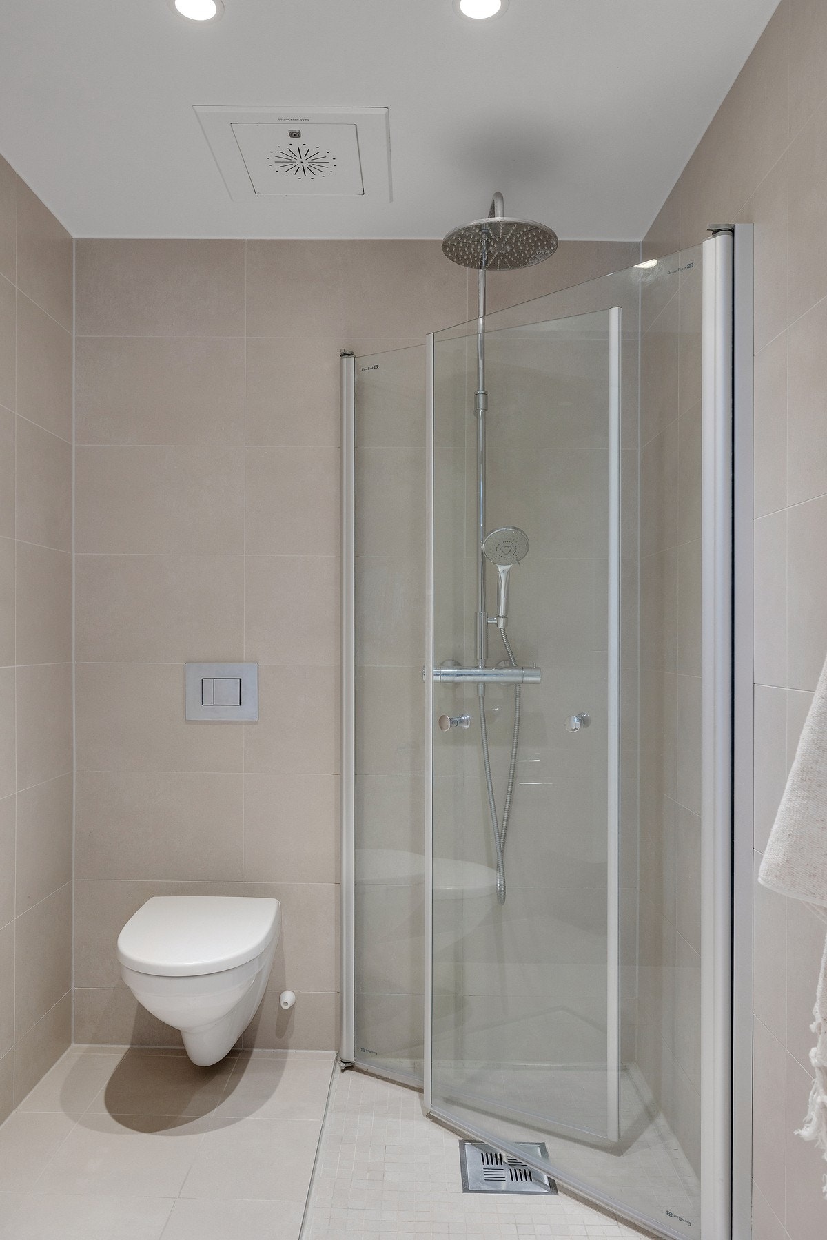 Badet er innredet med vegghengt toalett med innebygd sisterne kasse, samt dusjhjørne med vegghengte dusjdører i glass. Galleribilde