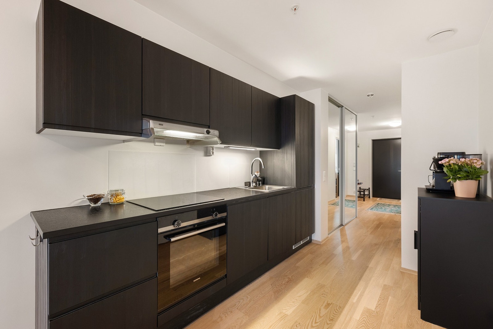 Dette stilrene, svarte kjøkkenet fra 2020 kombinerer minimalistisk design med funksjonalitet for et tidløst uttrykk. Galleribilde