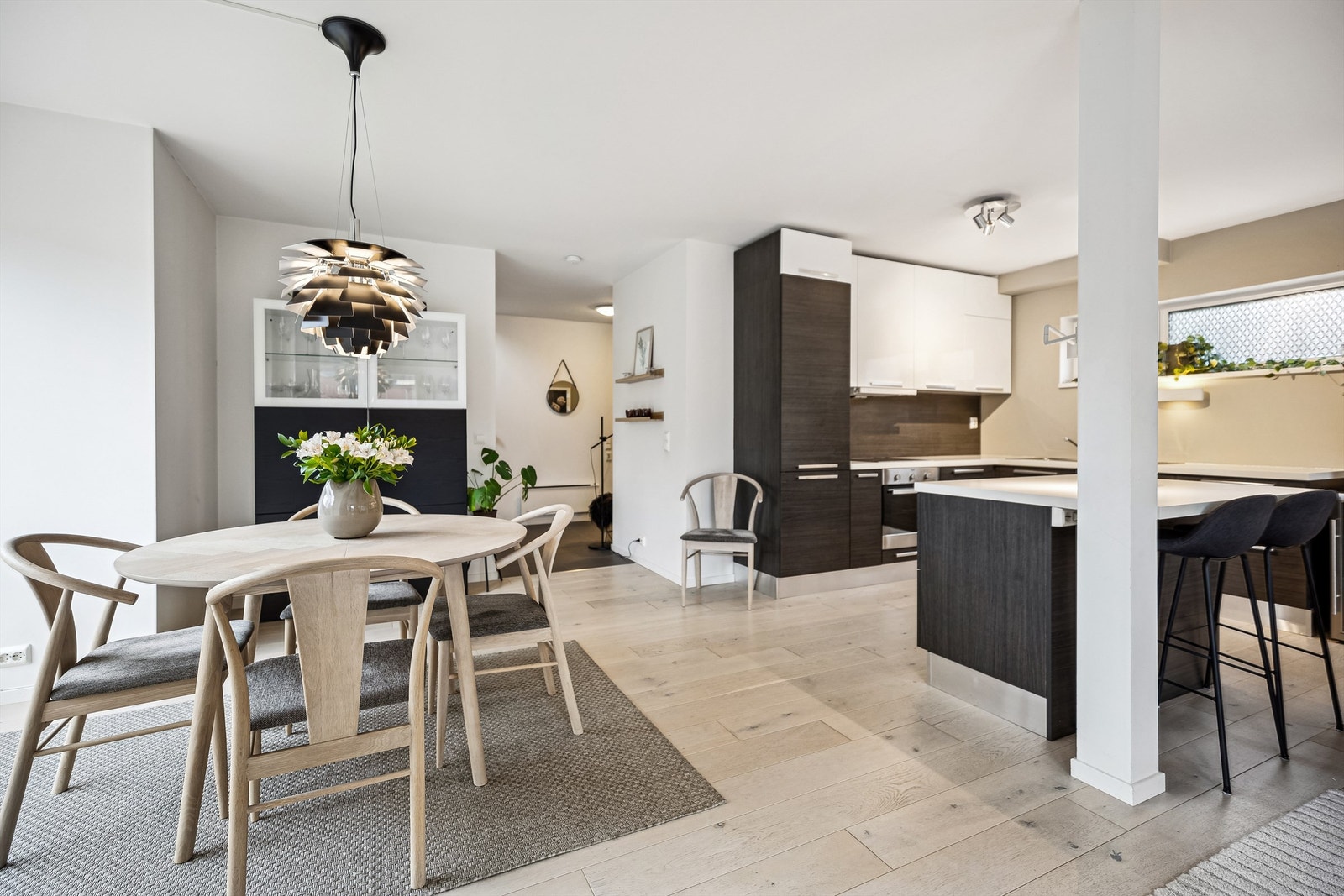 Innbydende stue og kjøkken i åpen løsning. Tiltalende farger og moderne kjøkkenløsning med en praktisk kjøkkenøy. Galleribilde