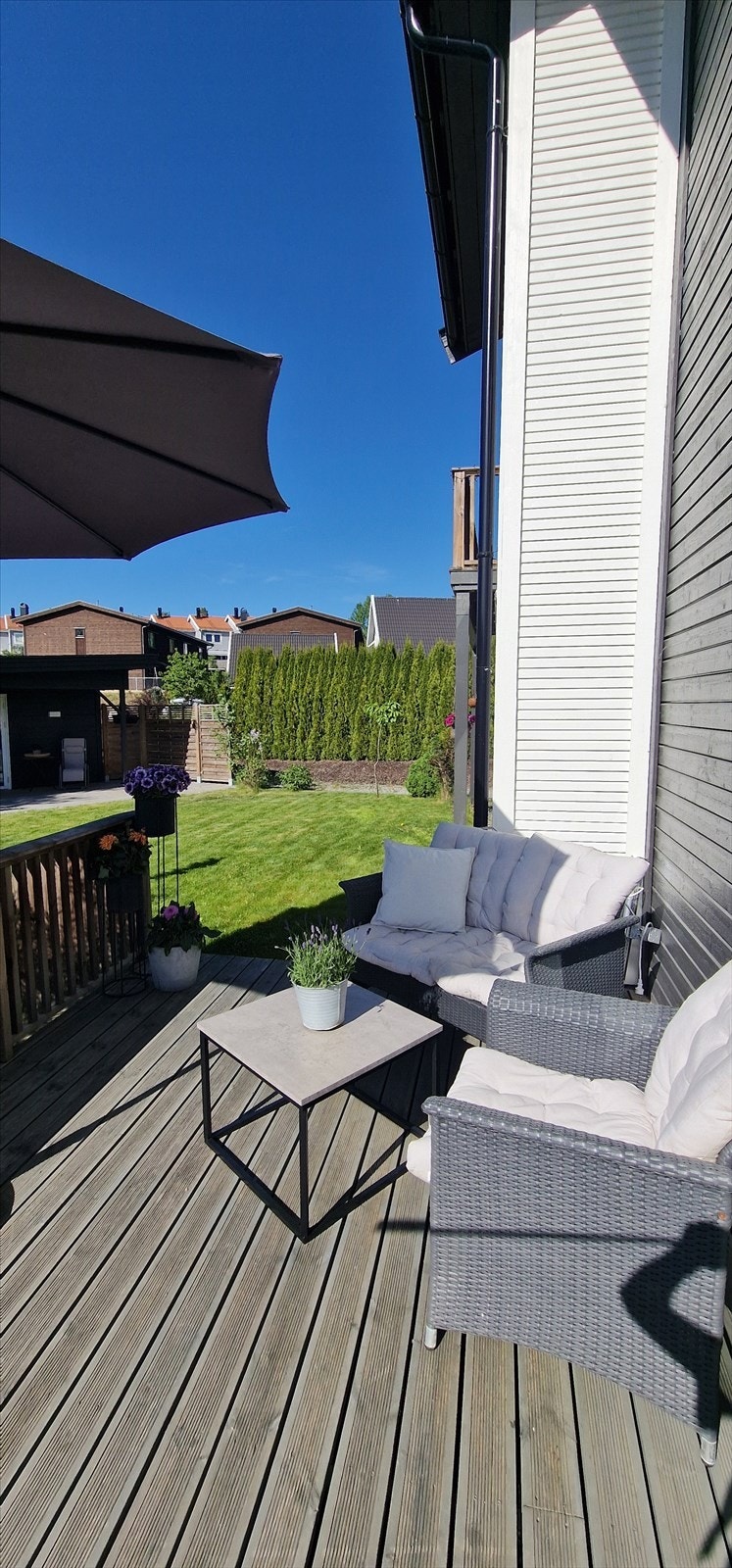 Eiendommen er pent opparbeidet med hekk, gressplen beplantninger og stor terrasse Galleribilde