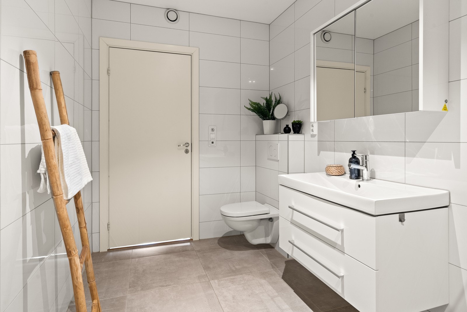 Det er hvit baderomsinnredning som består av servant med skuffer under, speilskap og vegghengt toalett. (Bilde fra tilsvarende bolig i 1. etasje). Galleribilde