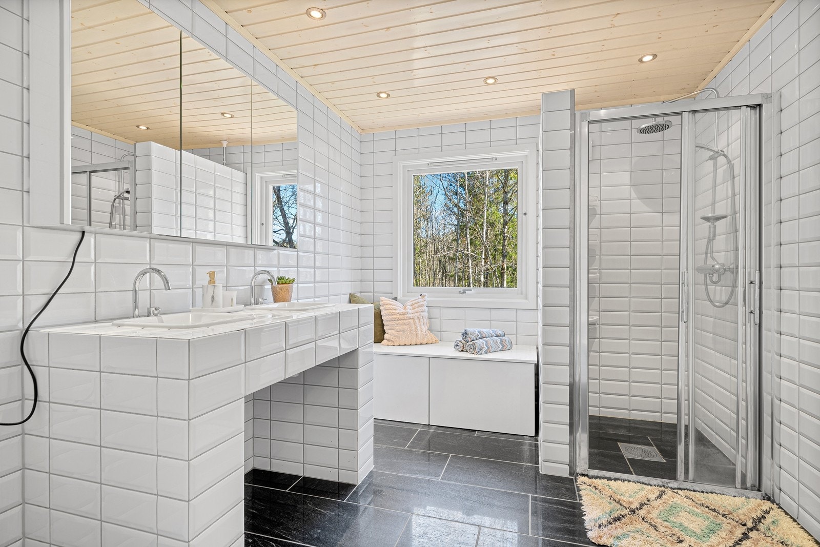 Lyst og fresht bad med romslig dusj, dobbelvask, praktisk speilskap og toalett Galleribilde