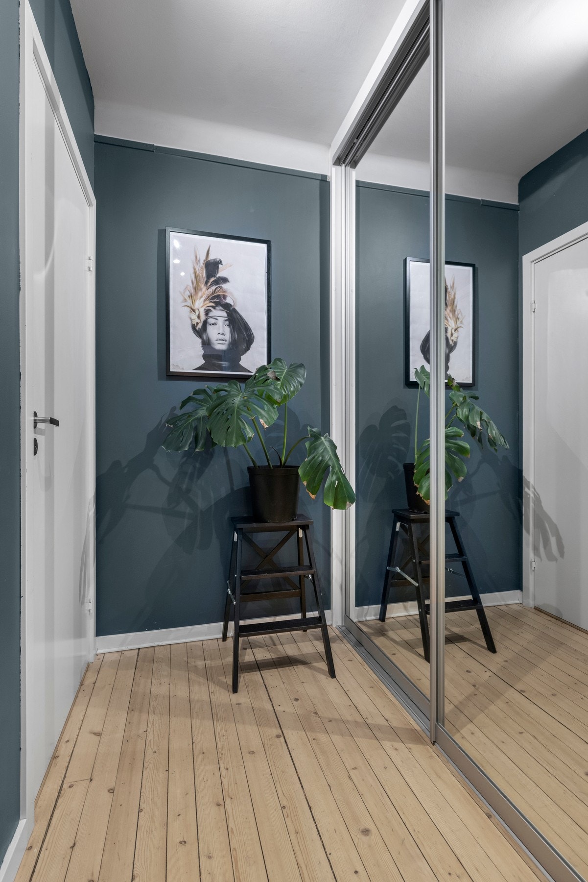 Rommet har tilknytning til et praktisk garderoberom som er innredet med skyvedørsgarderobe med speilfronter Galleribilde