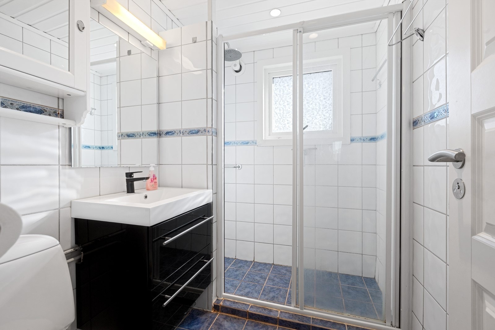 Eldre bad/wc med fliser på gulv og vegger, dusjnisje med glassdør og LED Downlights i tak Galleribilde