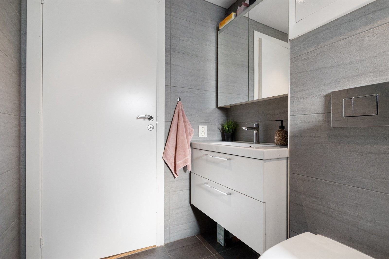 Her er det innredet med vegghengt toalett, dusj, servant med møblement, speil og belysning. Galleribilde