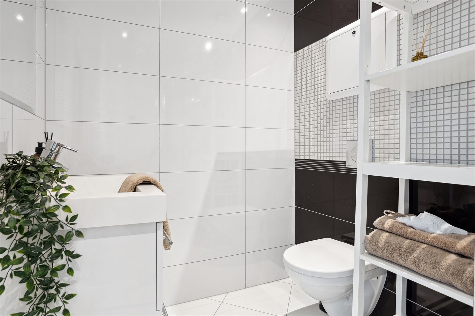 Badet er innredet med benkeskap med servant, foldedører i dusj og toalett. I tillegg er det varme i badegulv Galleribilde