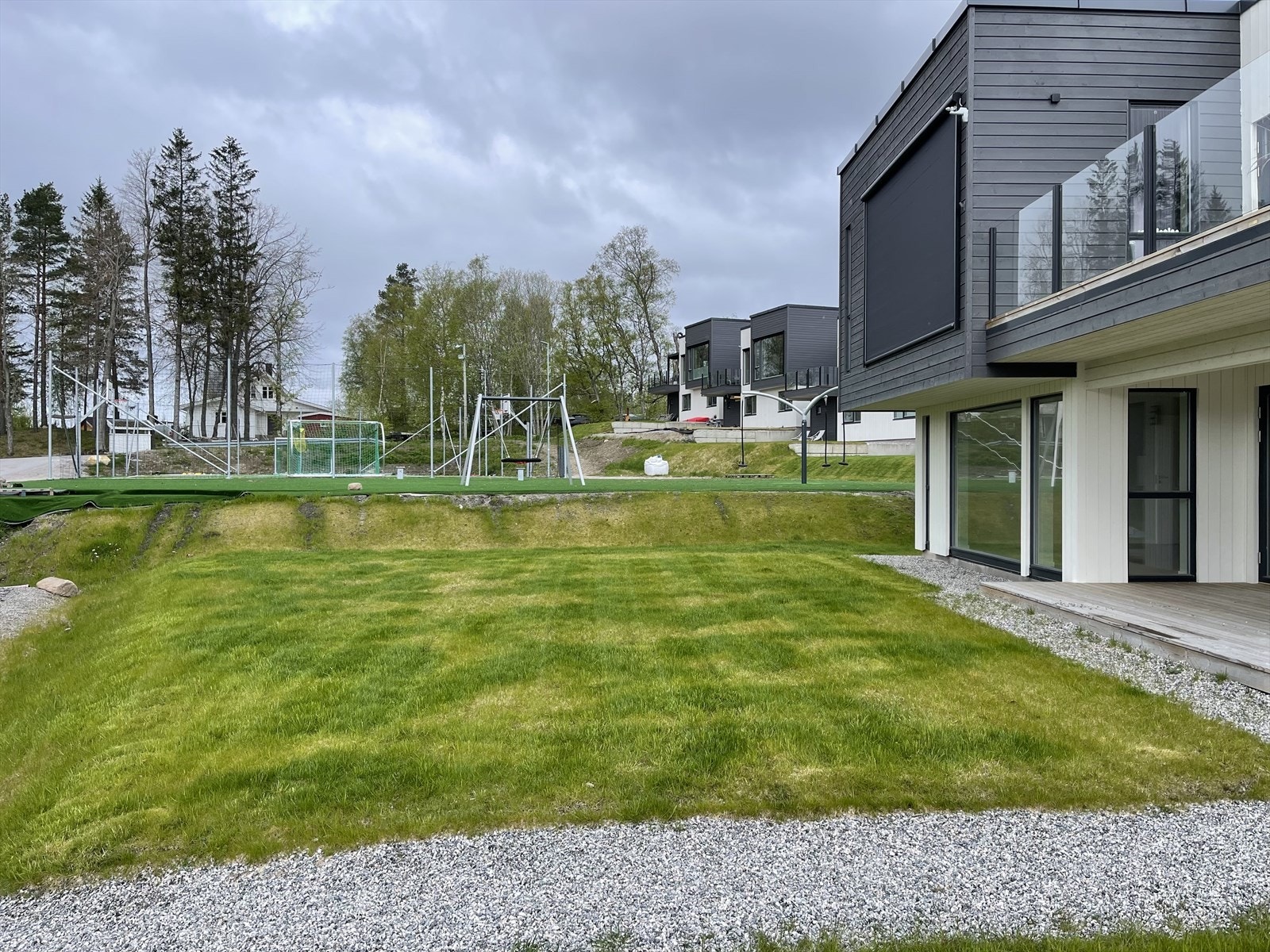 Tomten er opparbeidet med plen og singel på gårdsplass. Flott opparbeidet ballbinge like ved boligene. Galleribilde