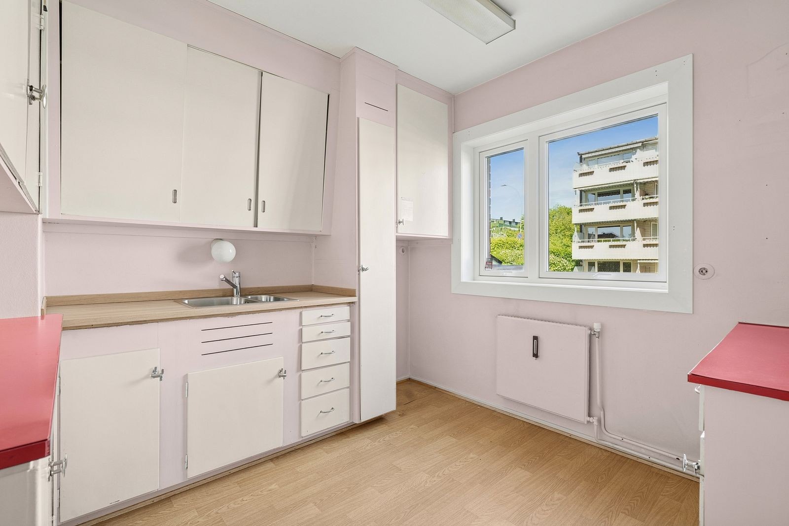 Separat kjøkken bestående av eldre innredning med glatte fronter Galleribilde