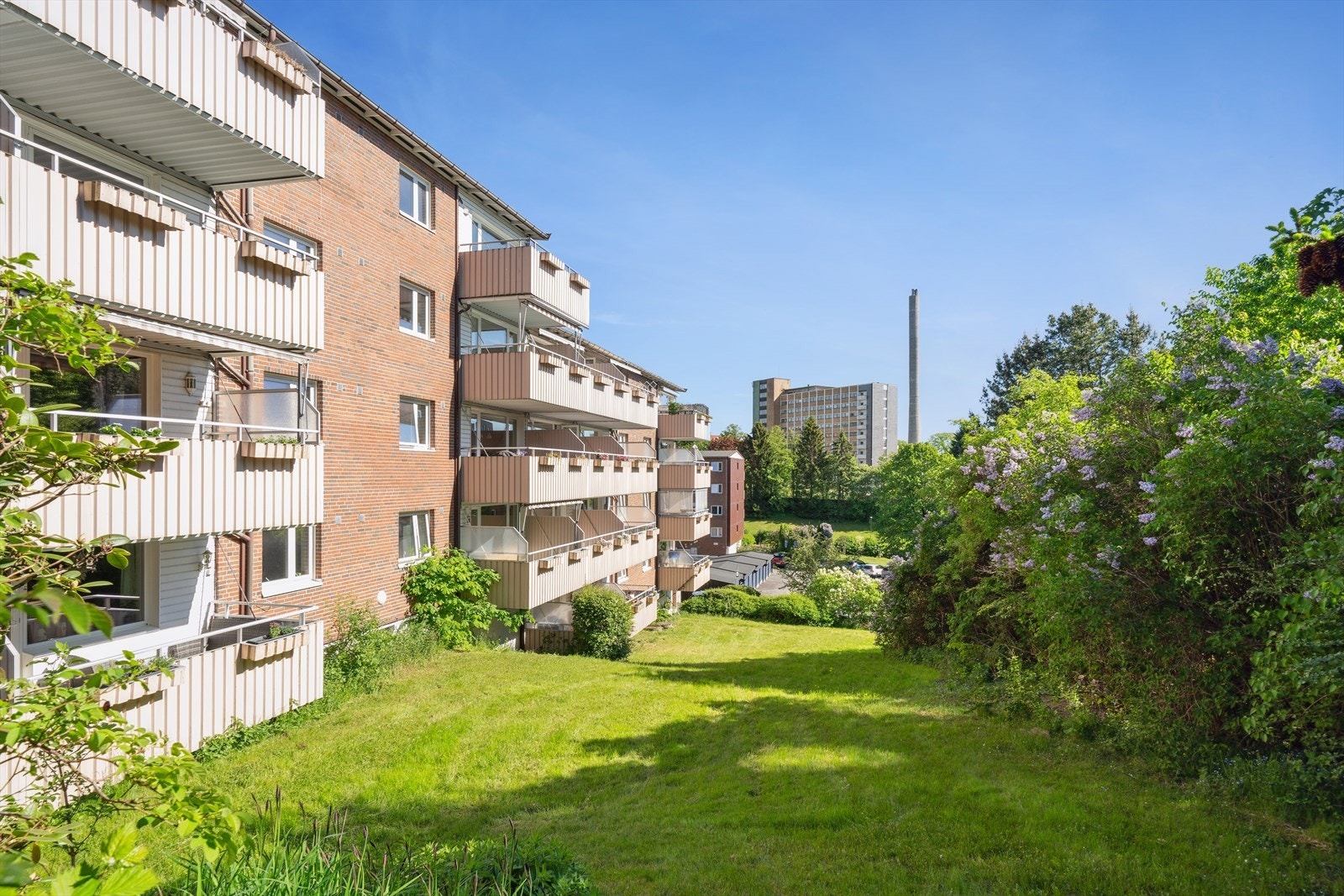 Borettslagets tom er pent opparbeidet med felles grøntarealer, sittegrupper og lekeapparater for barn Galleribilde