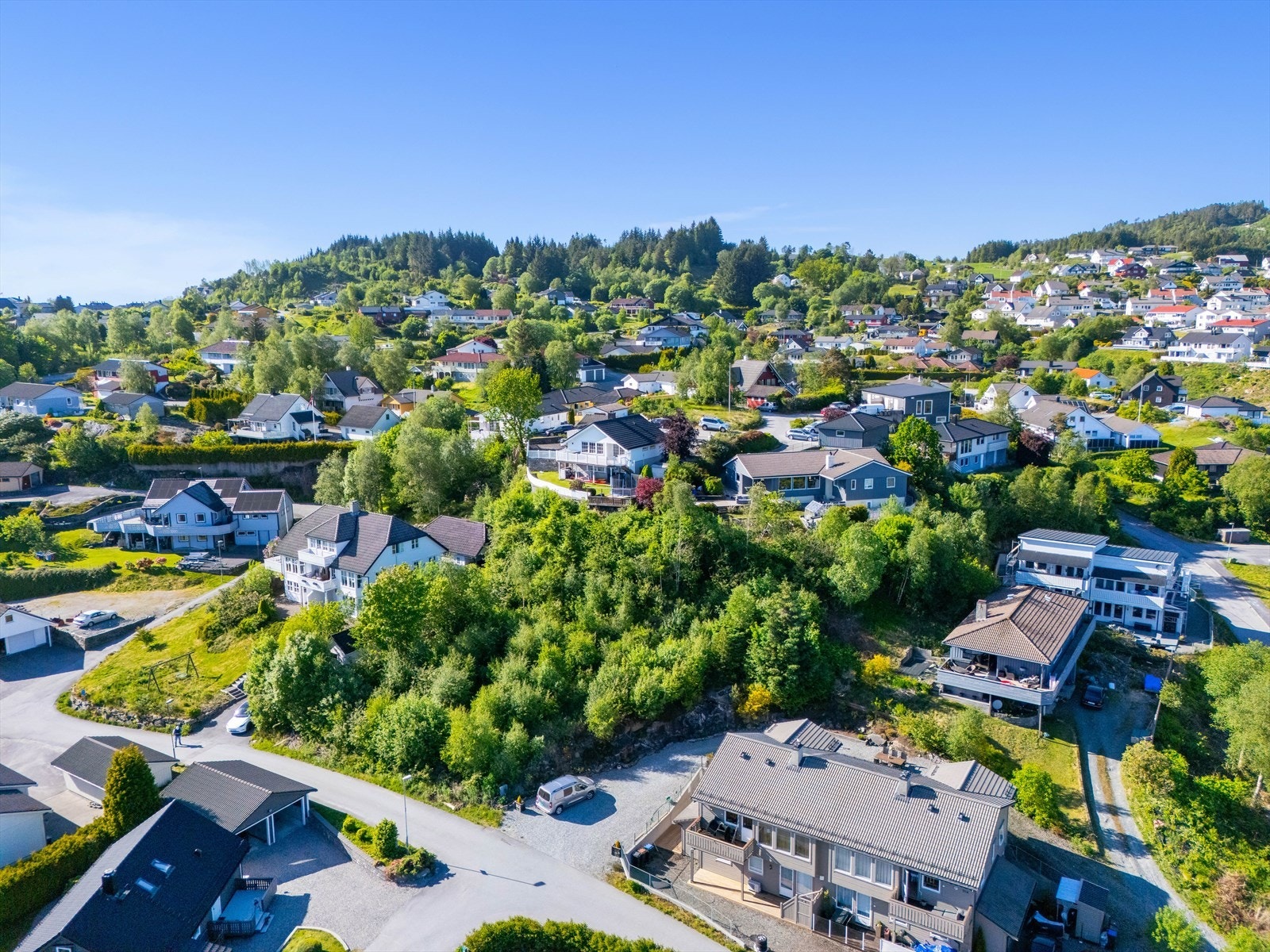 Tomten er reklangulær og strekker seg fra veien i sør og opp mot naboer i nord. Bod/uthus man skimter til venstre er inne på denne eiendommen Galleribilde