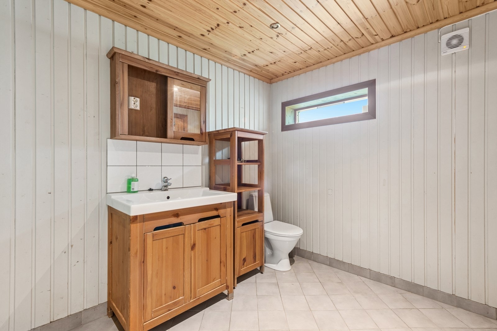 Baderommet er av ukjent alder og har flislagte gulvflater samt panel/tømmer på veggene. Galleribilde