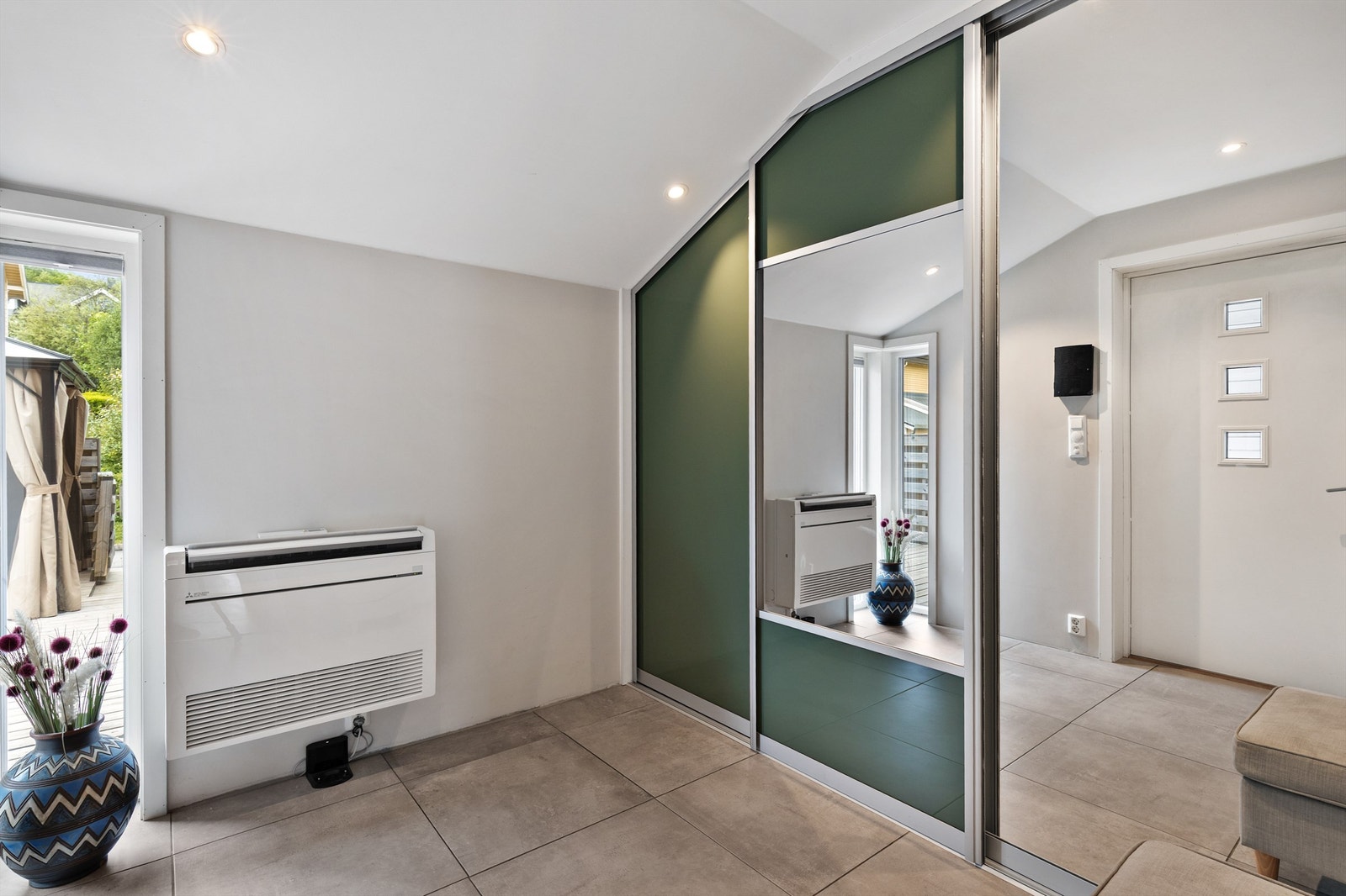 Velkommen inn! Entréen er av god størrelse med plass til å henge fra seg yttertøy og sko i en romslig skyvedørsgarderobe. Galleribilde