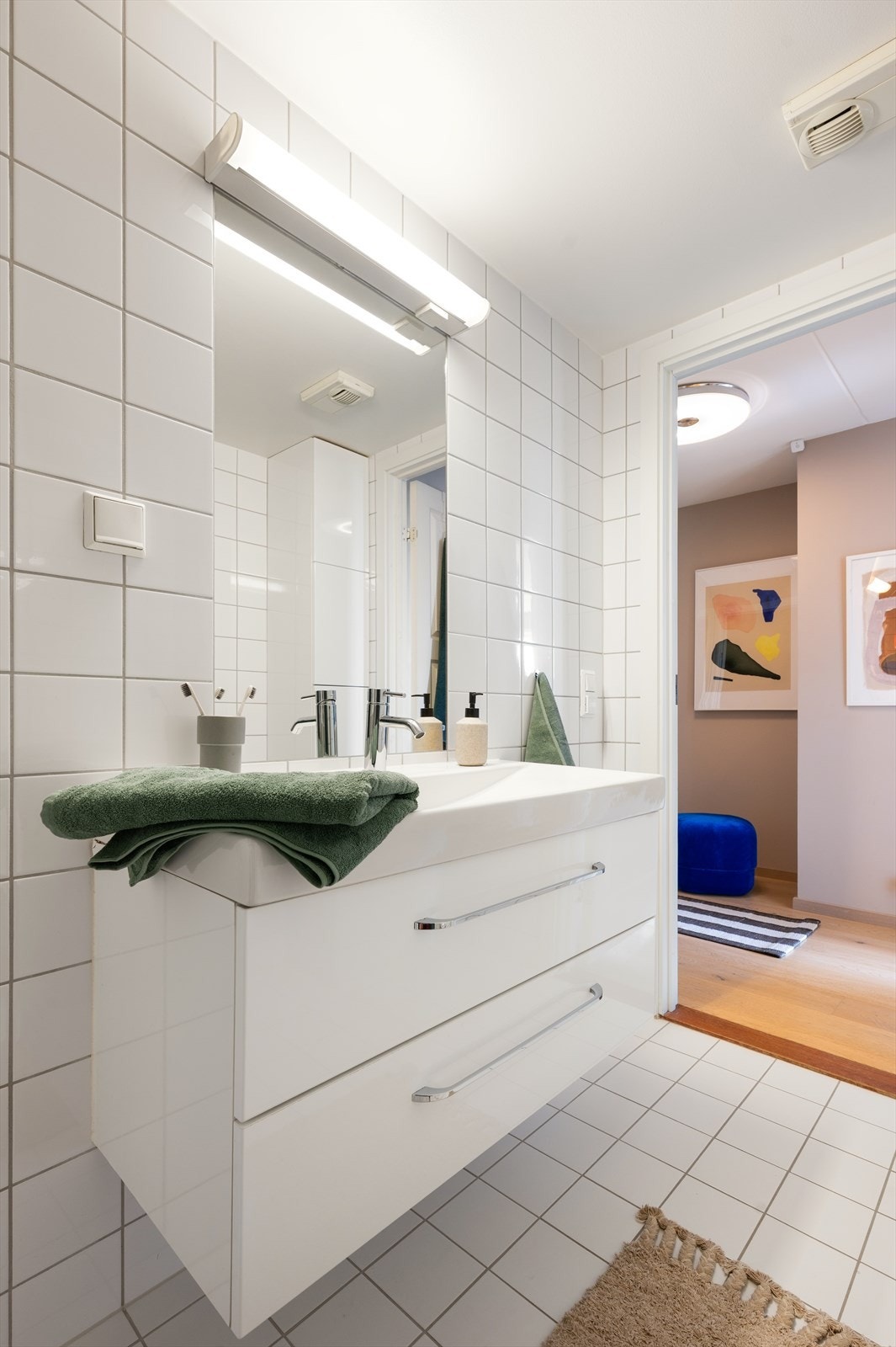 Badet er innredet med heldekkende servant på underskap, speil med belysning, toalett og dusjhjørne med herdede glassdører. Galleribilde