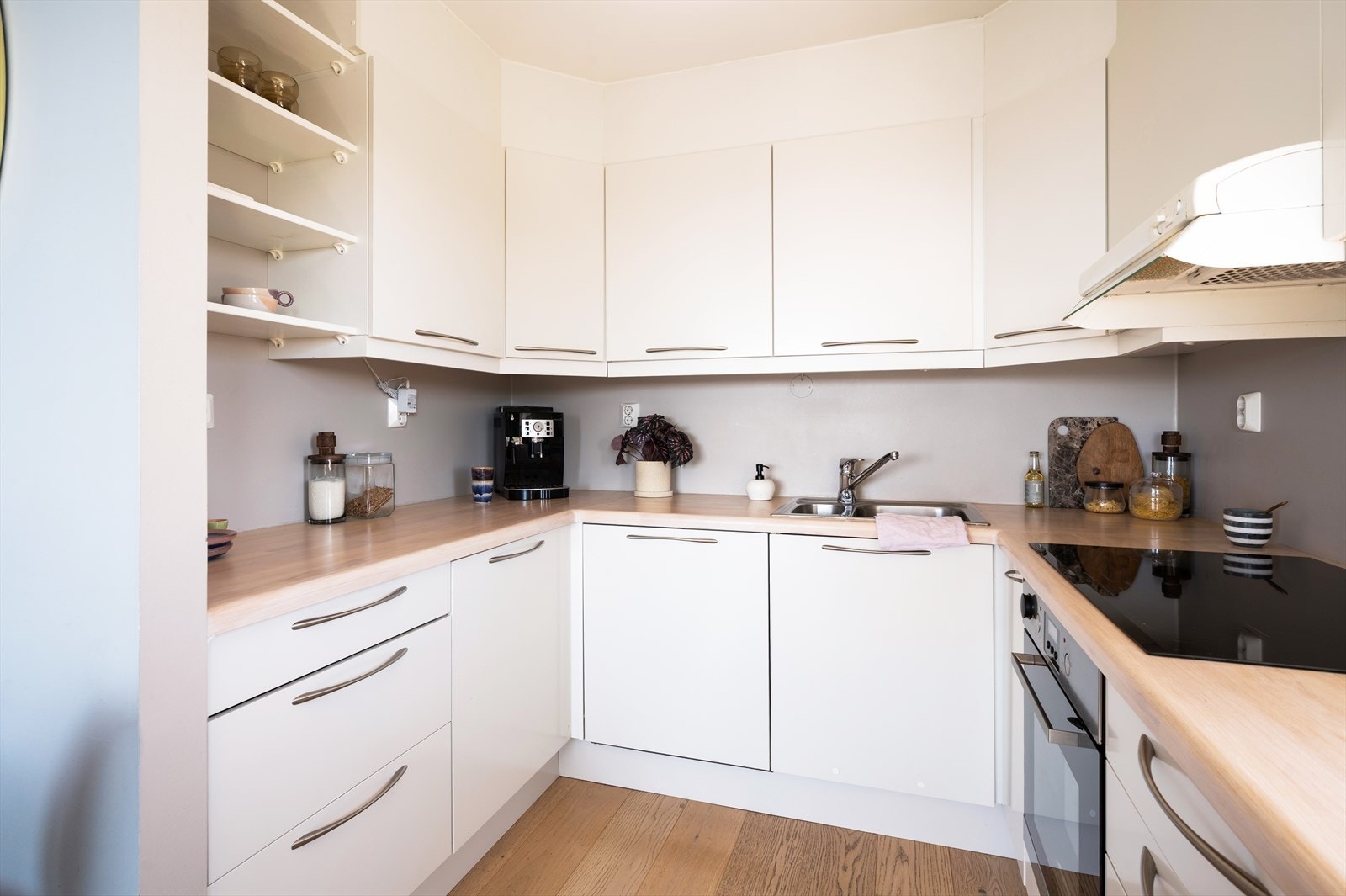 Moderne kjøkkeninnredning fra byggeår med hvite, slette fronter og benkeplate i heltre fra 2014. Galleribilde