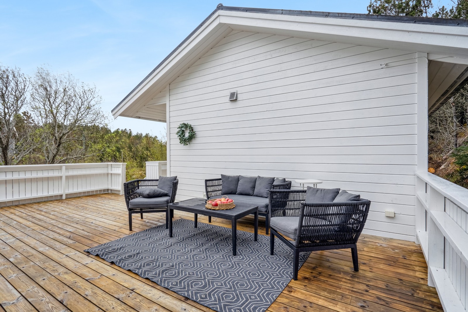 Solrik terrasse med plass til ulike sittegrupper, utemøblement m.m. Galleribilde