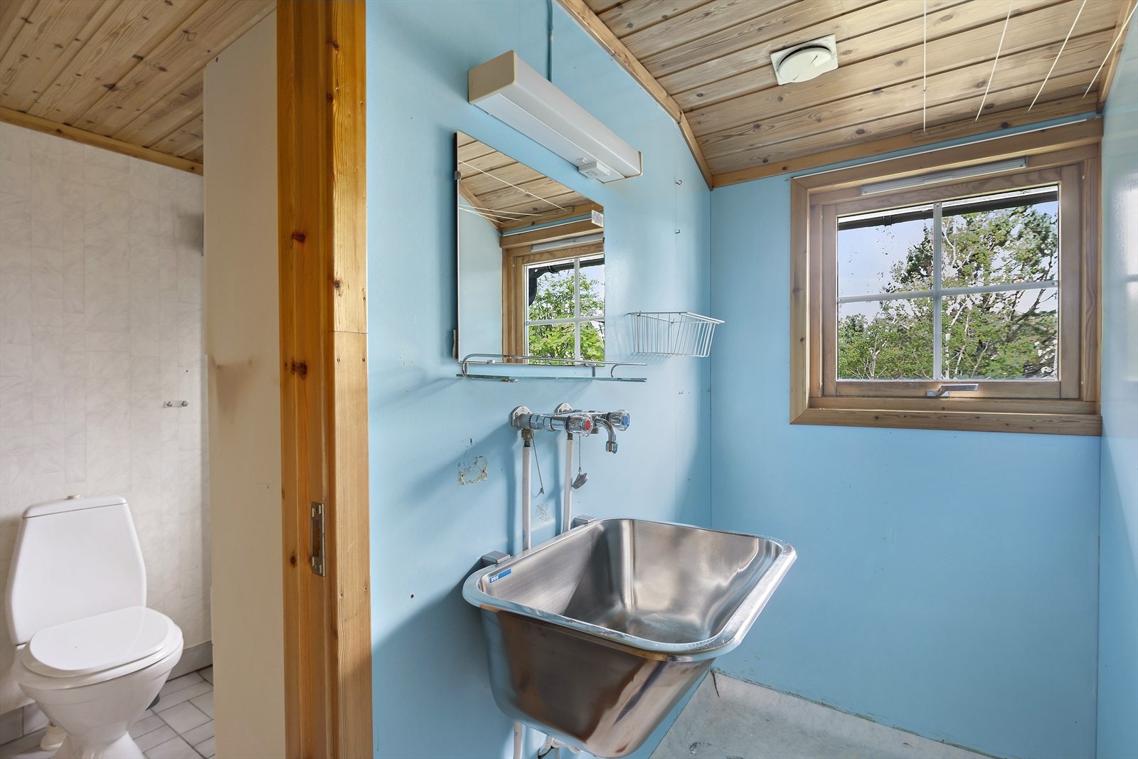 Det eldre baderommet har flislagt gulv med varmekabler, innredning med sjalusidører, nedfelt vask, dusjkabinett og toalett. Vaskerommet er også av eldre dato, men meget funksjonelt med skyllekar og opplegg for vaskemaskin. Galleribilde