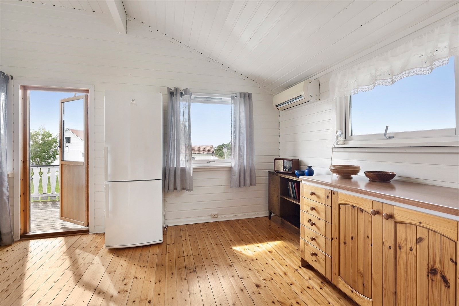 Spisestue. Kjøkkenet er et koselig og funksjonelt rom, med lakkert furugulv og paneling på både vegger og tak som gir en rustikk og hjemmekoselig følelse. Galleribilde