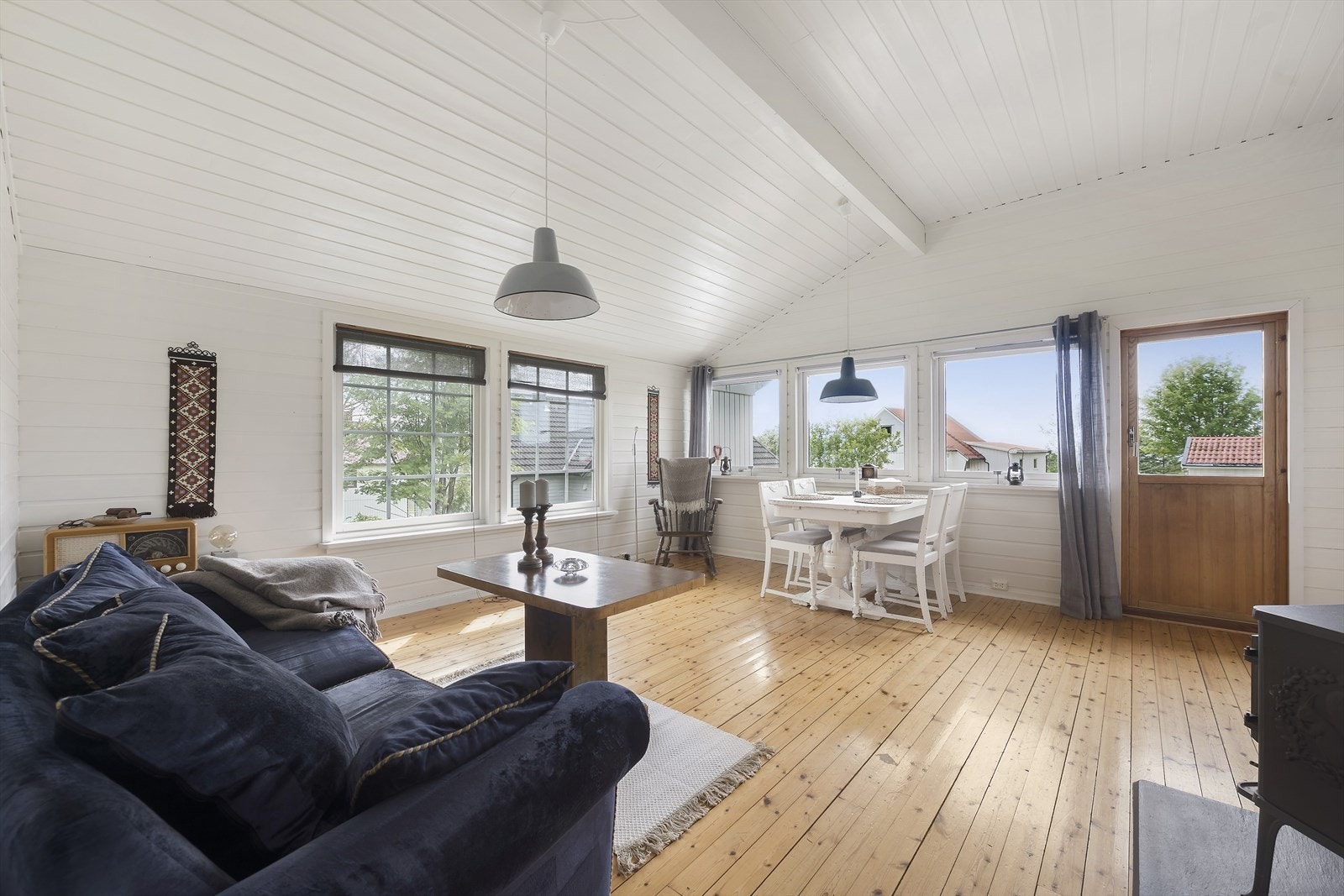 Rommet er stort nok til både avslapping og sosiale sammenkomster, med utgang til en romslig veranda som forlenger oppholdsarealet utendørs. Galleribilde