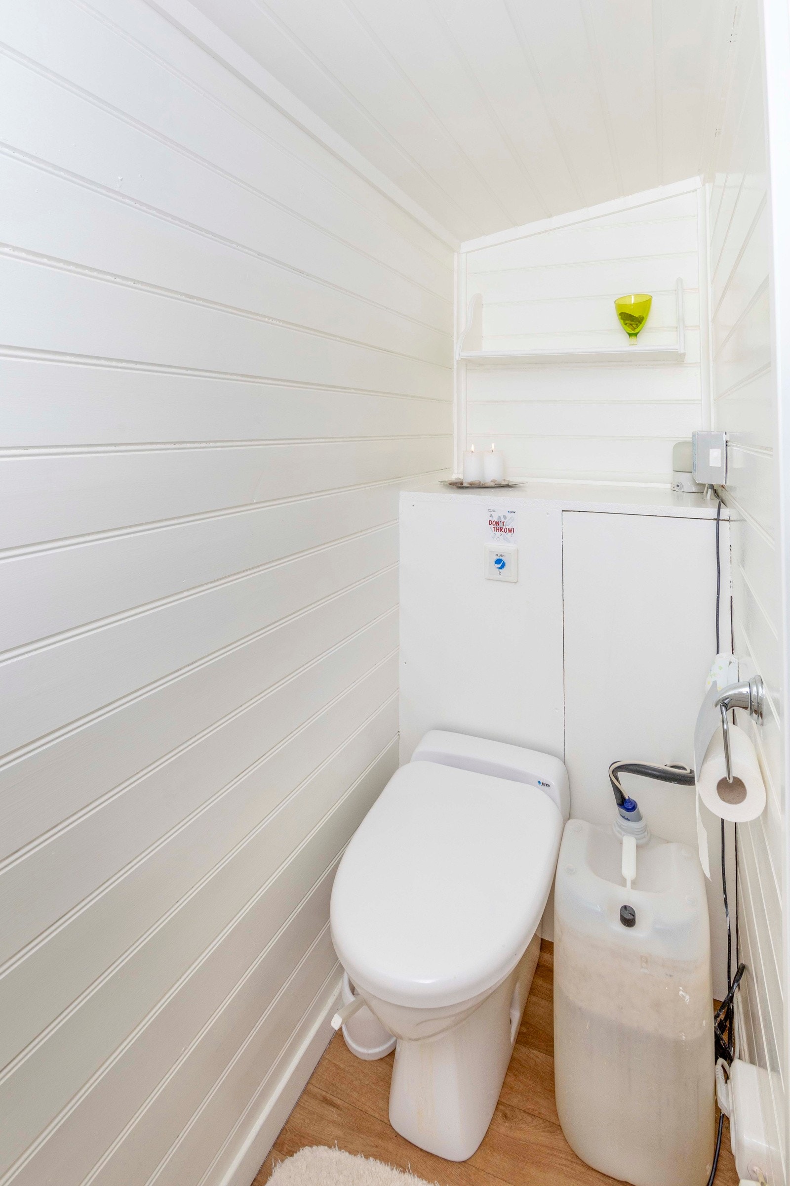 Toalettrom har laminat på gulv, vegger og tak med malt panel, skråhimling. Toalettet er et Jets vacumtoalett med spyling fra vanntank/kanne til glassfiber-kum under hytta og avtrekk over tak. Galleribilde