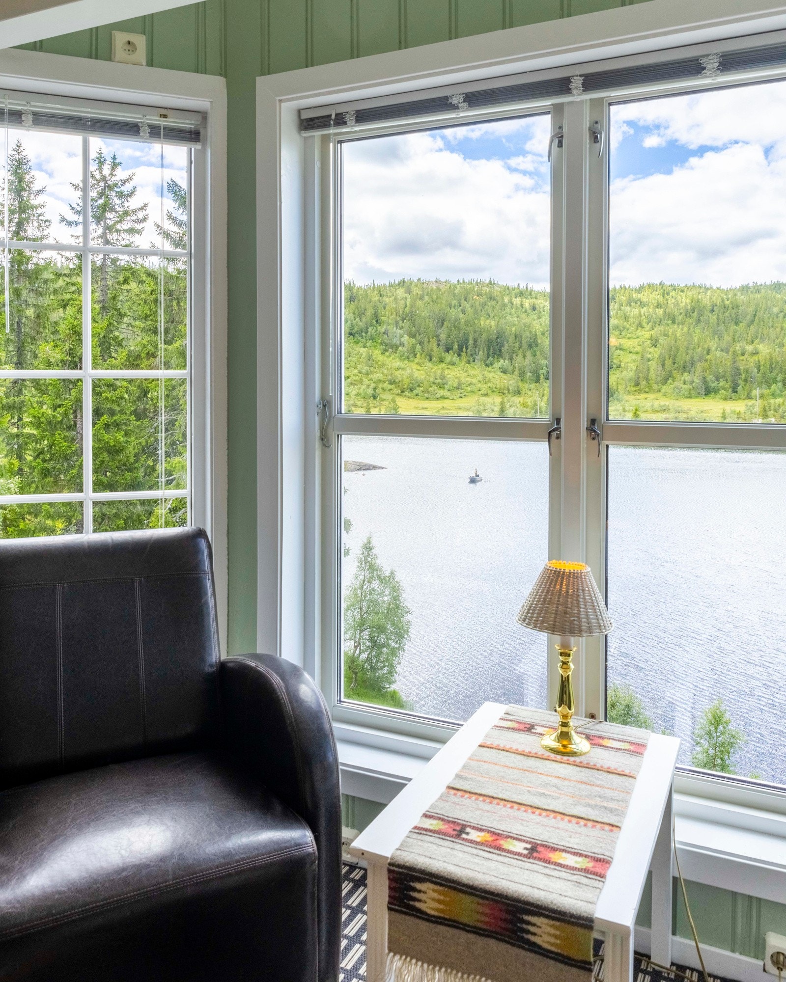 Stuen har store vindusflater som slipper rikelig med naturlig lys inn som gir en behagelig atmosfære Galleribilde