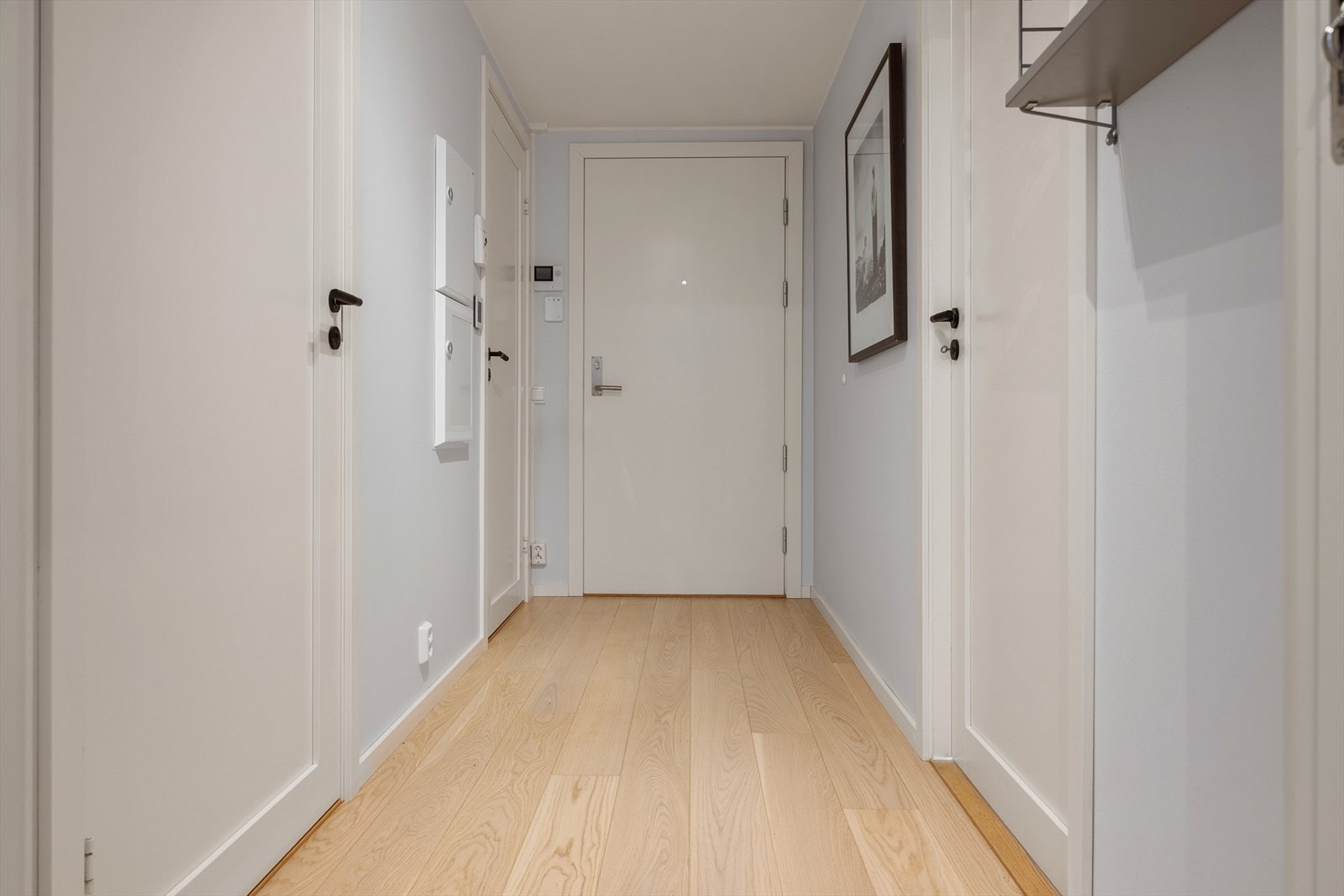 Vi møtes av en lys og innbydende entre. Her får vi et umiddelbart inntrykk av boligens moderne standard. Den innvendige boden ved inngangspartiet, som måler 2,1 kvm, har plass til garderobeskap, skohylle eller knagger for oppheng av yttertøy. Galleribilde