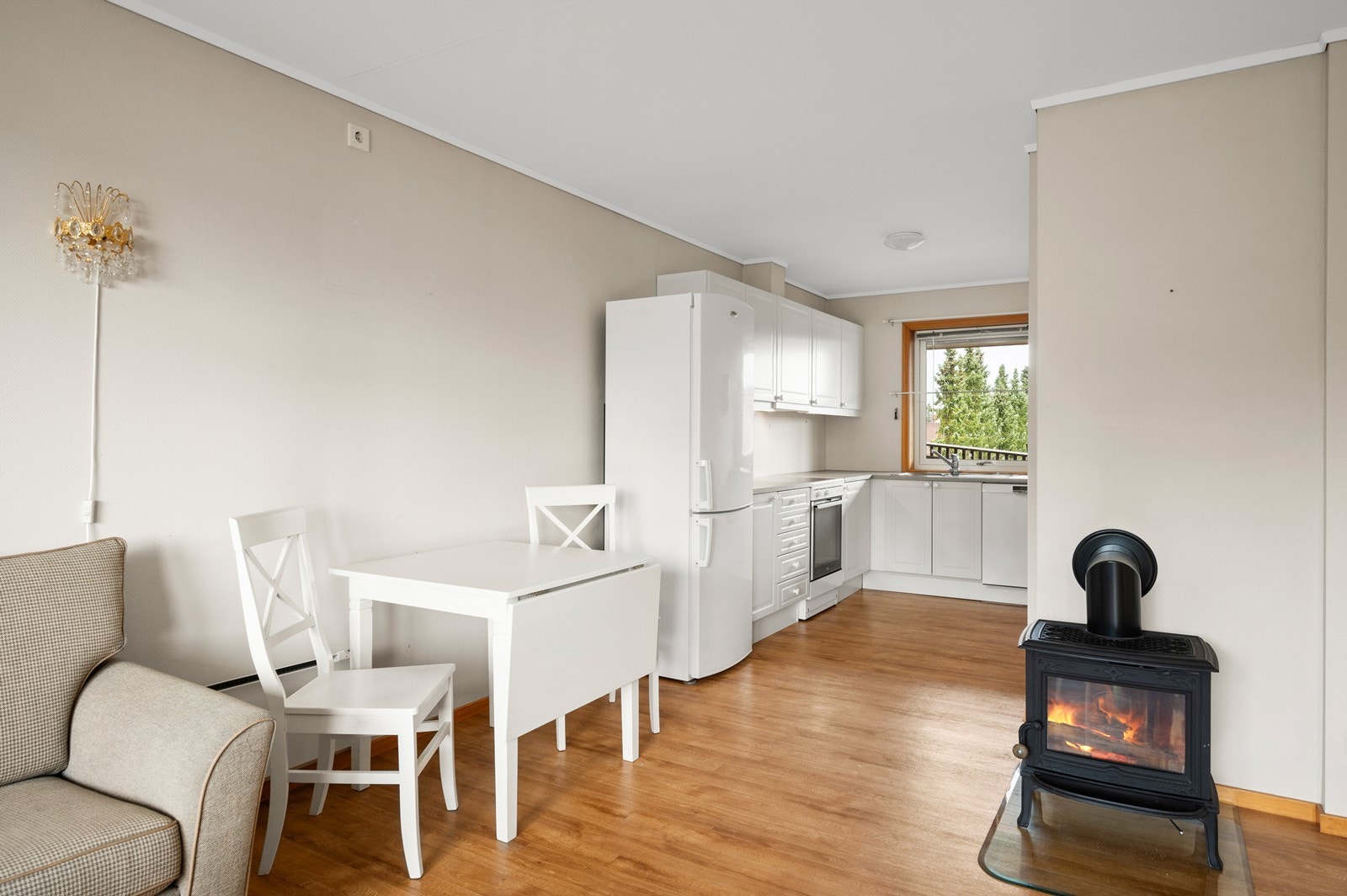 Kjøkkenet har innredning med malte profilerte fronter og laminat benkeplate Galleribilde