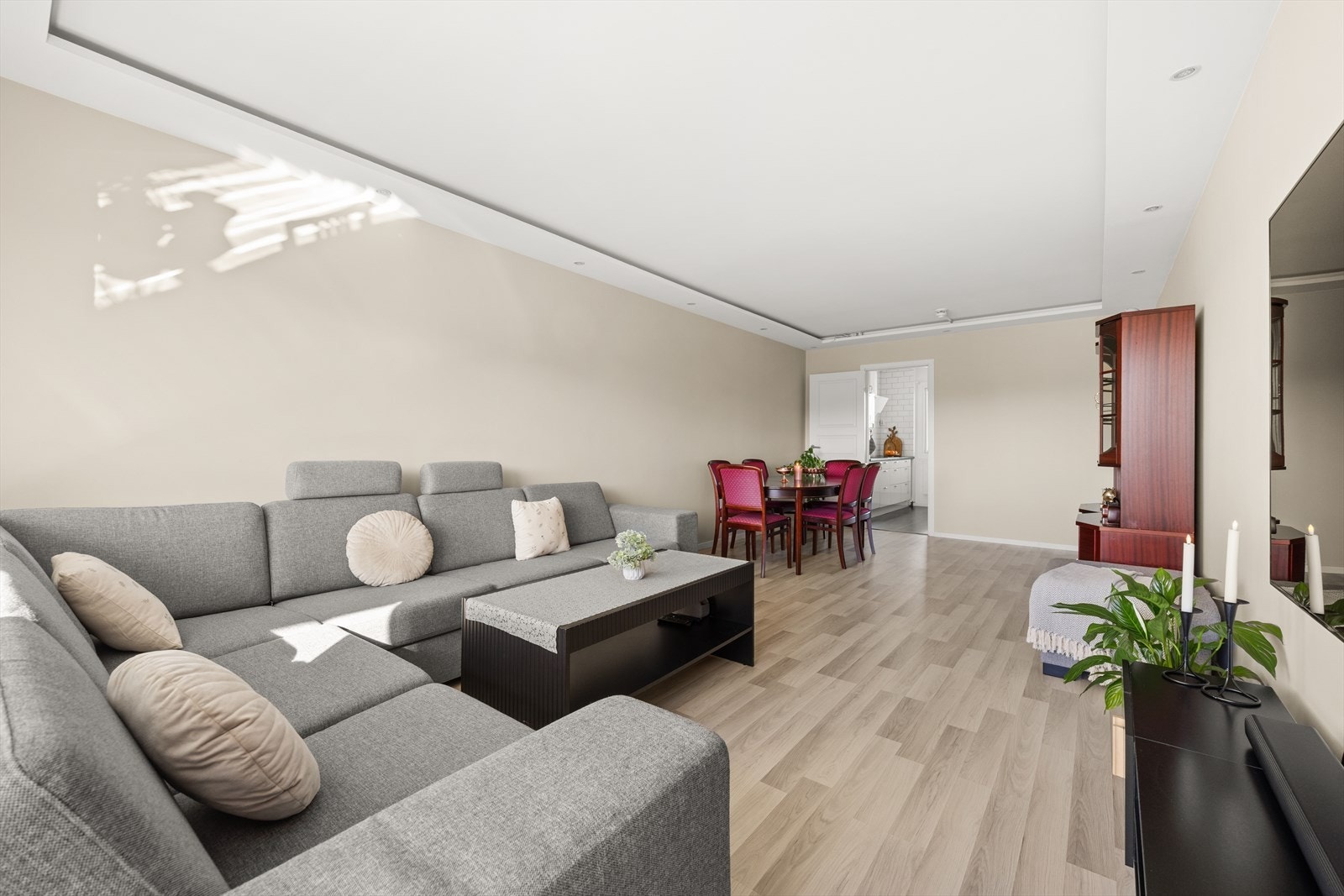 Leiligheten har en lys og fin stue med glatte overflater og downlights Galleribilde