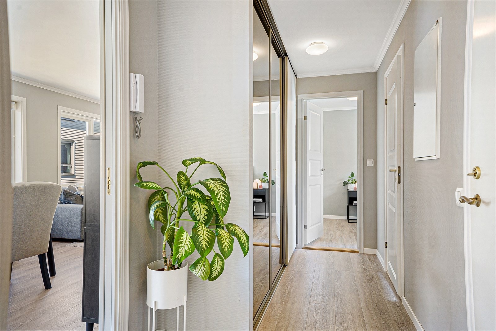 Lys og romslig gang med stor skyvedørsgarderobe Galleribilde