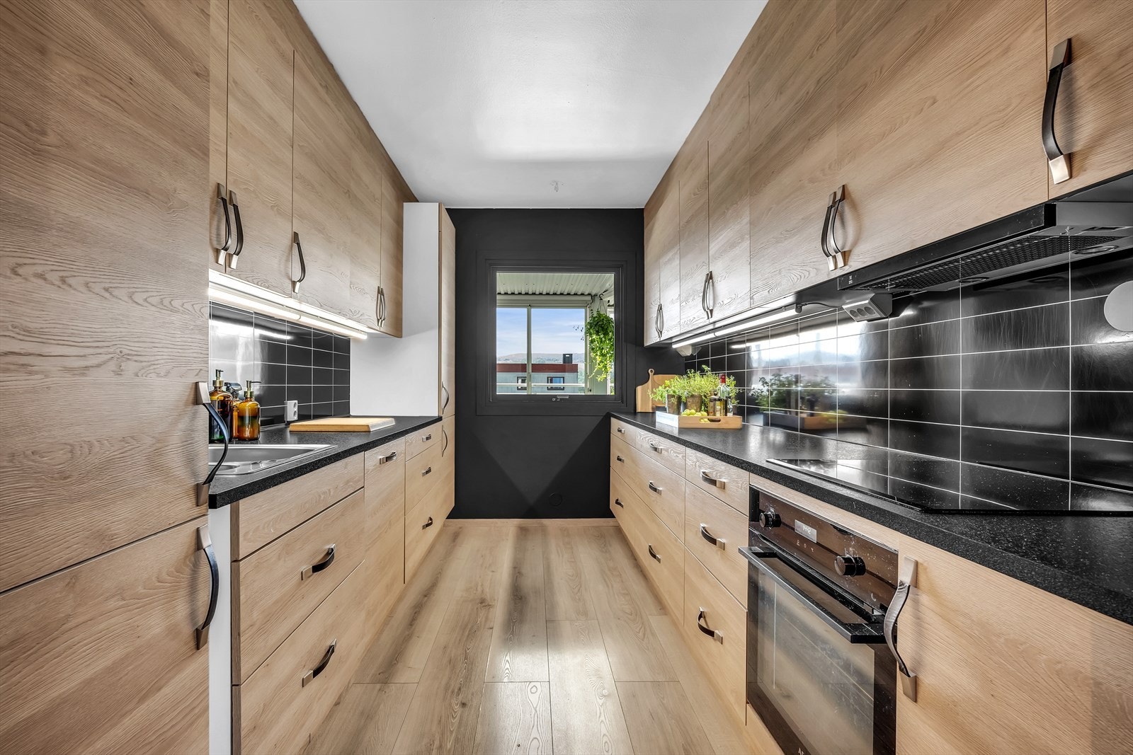 Pent kjøkken fra 2019 med glatte fronter og laminert benkeplate. Galleribilde