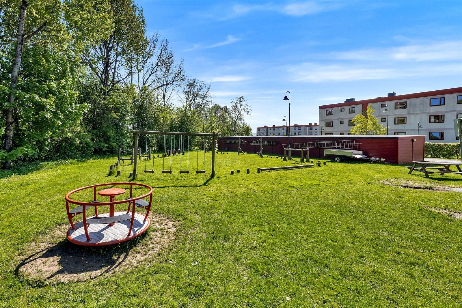 Borettslagets tomt er pent opparbeidet med plen, beplantning og lekeplass. Galleribilde