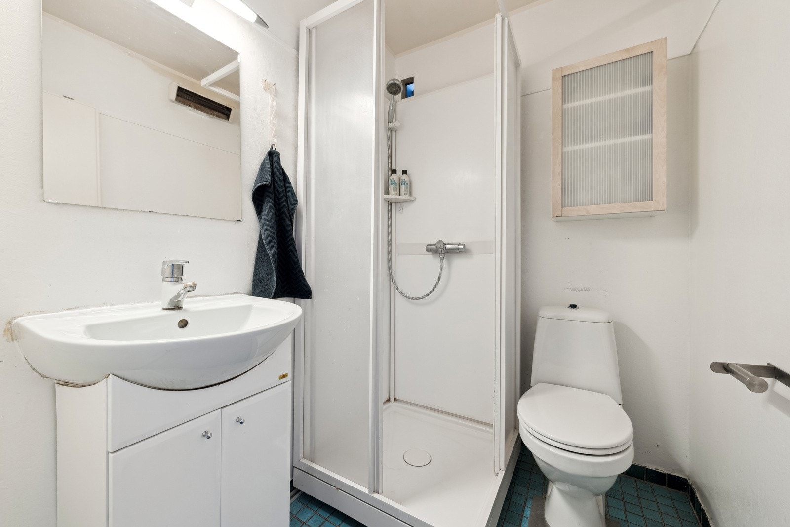 Baderom med flislagt gulv og veggoverflater i malte glatte flater. Galleribilde