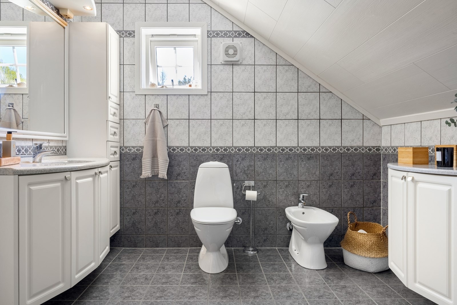 Badet er utstyrt med dusj, toalett, bide og baderomsinnredning med vask og speil med spotter over for belysning. Galleribilde