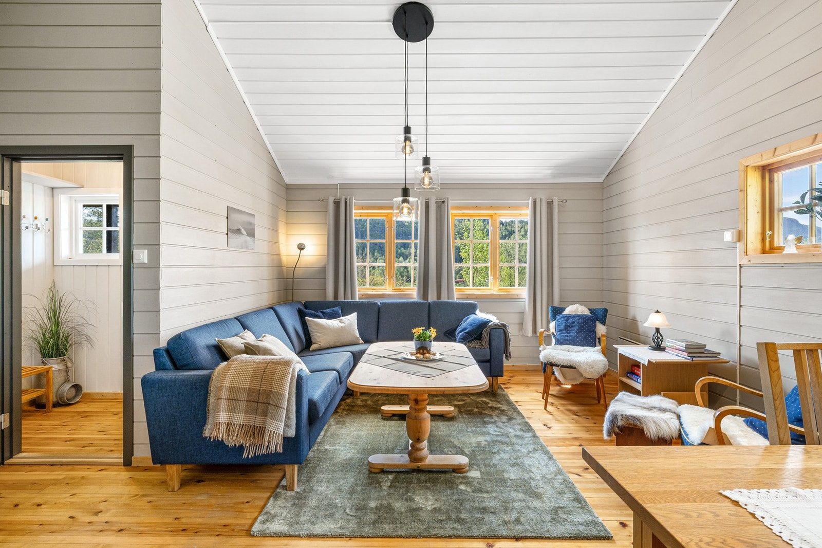 Åpen og luftig planløsning som kombinerer stue og kjøkken i ett felles oppholdsrom, ideelt for sosialt samvær og avslapning. Galleribilde