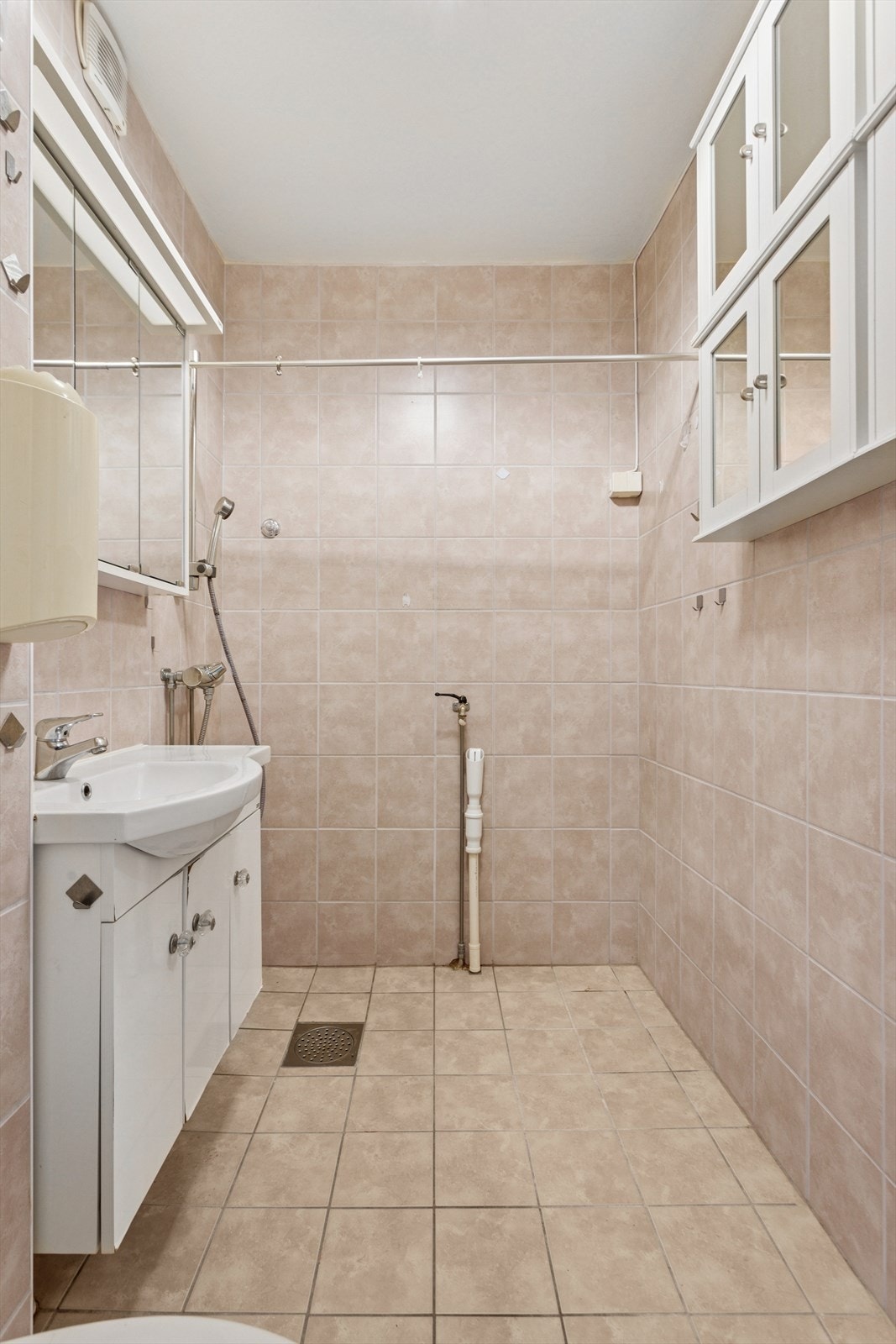 Dusjen er plassert innerst på badet, praktisk utformet med flislagte vegger og god drenering. Et funksjonelt og ryddig våtrom. Galleribilde