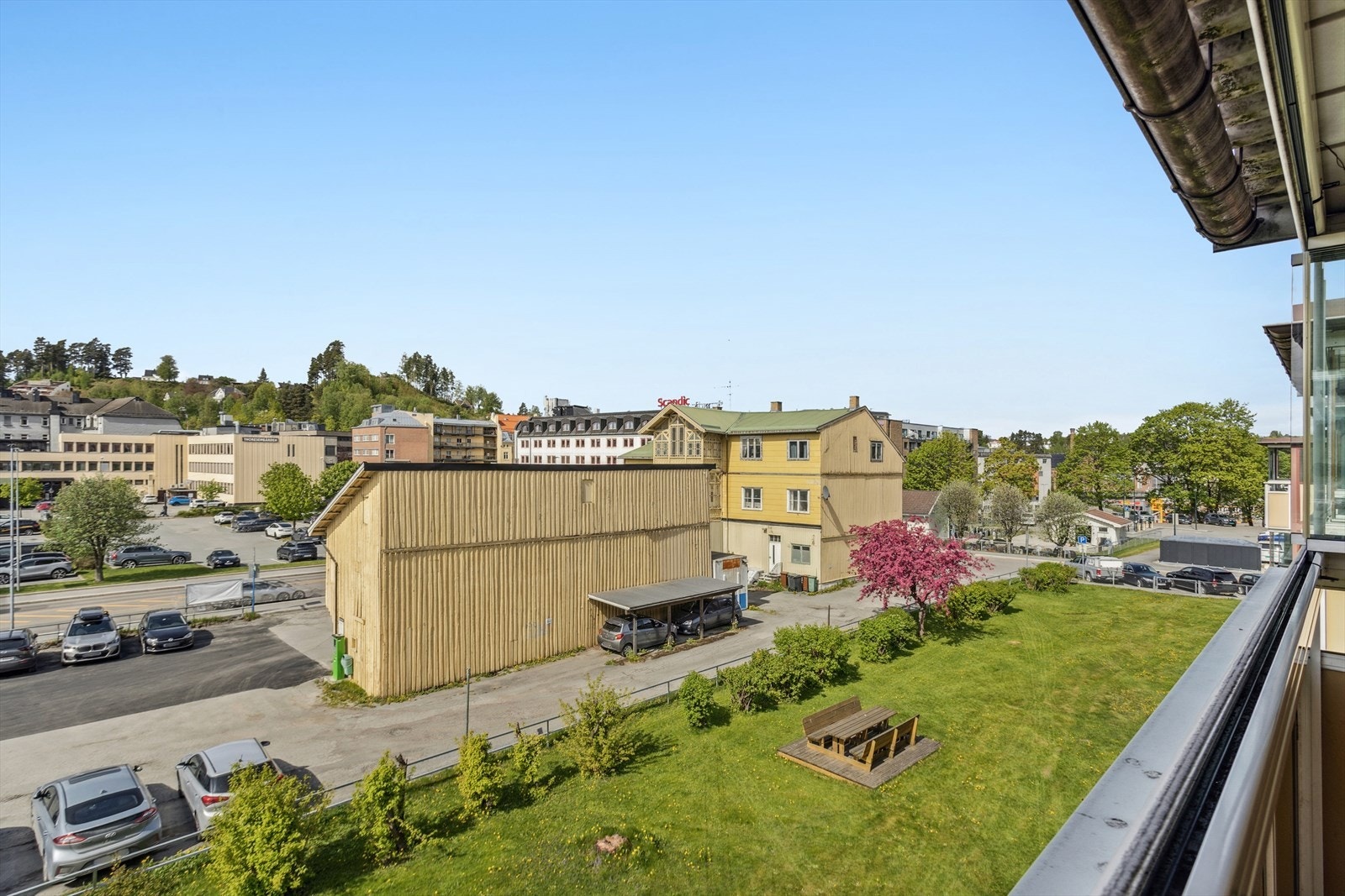 Leiligheten vender ut mot et hyggelig fellesområde med plen og sittebenk - et perfekt sted for en pause i solen. Galleribilde