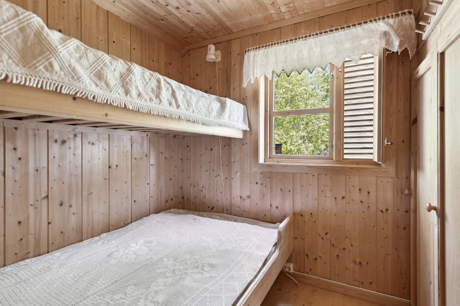 Soverom med dobbeltseng og overkøye samt plassbygde garderobeskap Galleribilde