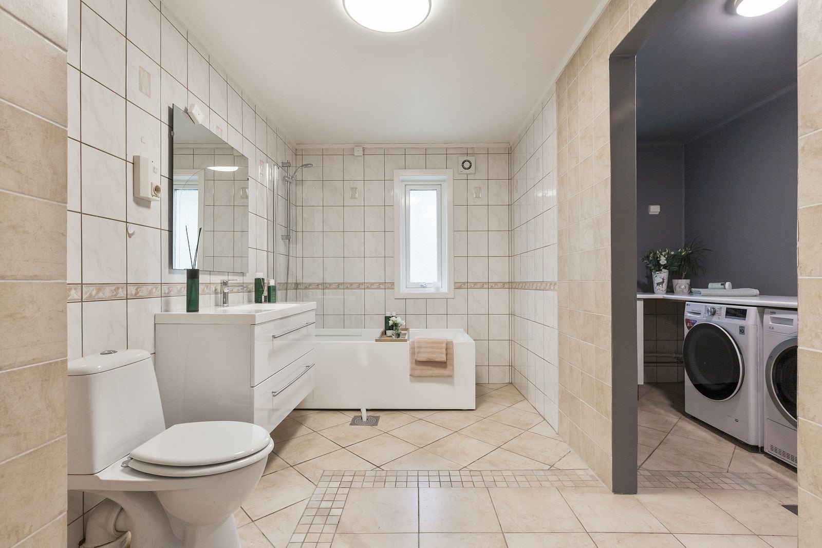 Praktisk baderom delt i to med en badedel og en vaskeromsdel. Galleribilde