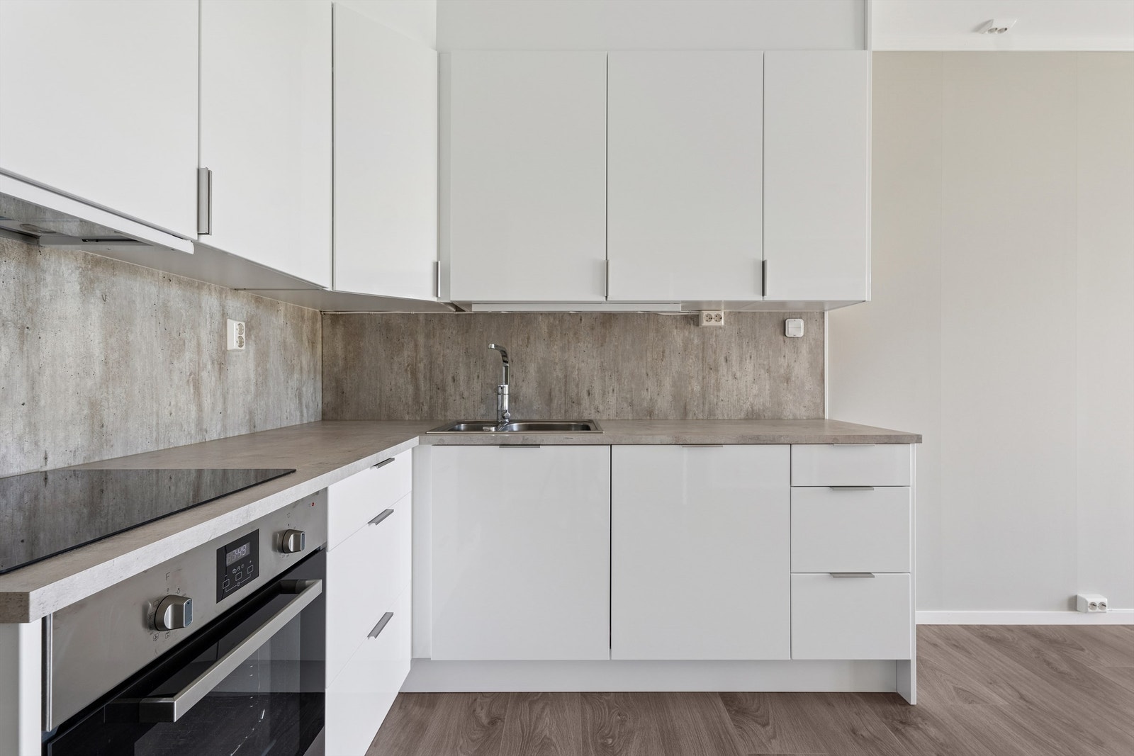 Kjøkkeninnredningen er fra SMART og består av hvite høyglansfronter og benkeplate av laminat med nedfelt oppvaskkum og kitchenboard i benkerygg. Galleribilde
