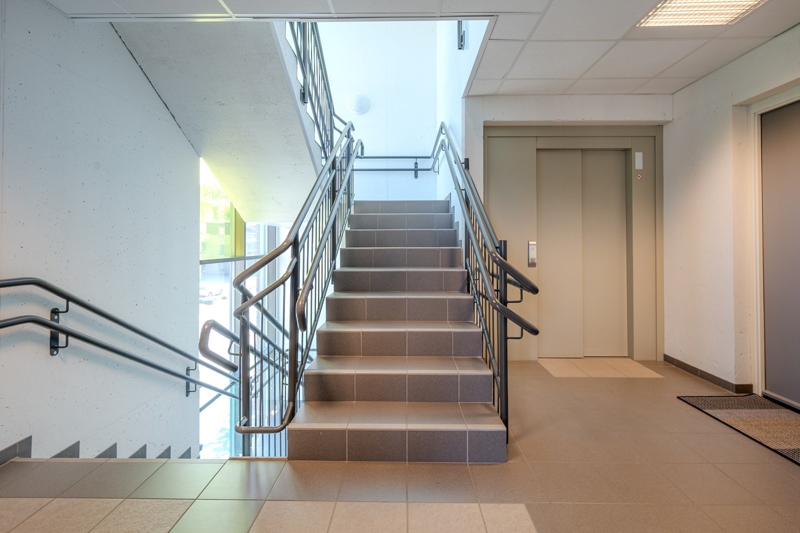 Ryddige fellesareal med heis til leilighetens etasje Galleribilde