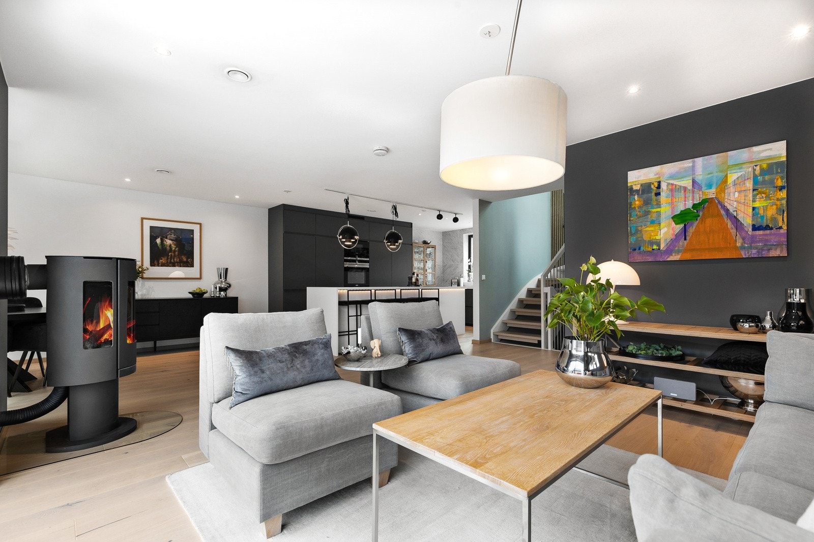 Stuen har fin utforming med naturlige soner for sofagruppe og spisebord. Lekker peison midt i rommet. Galleribilde