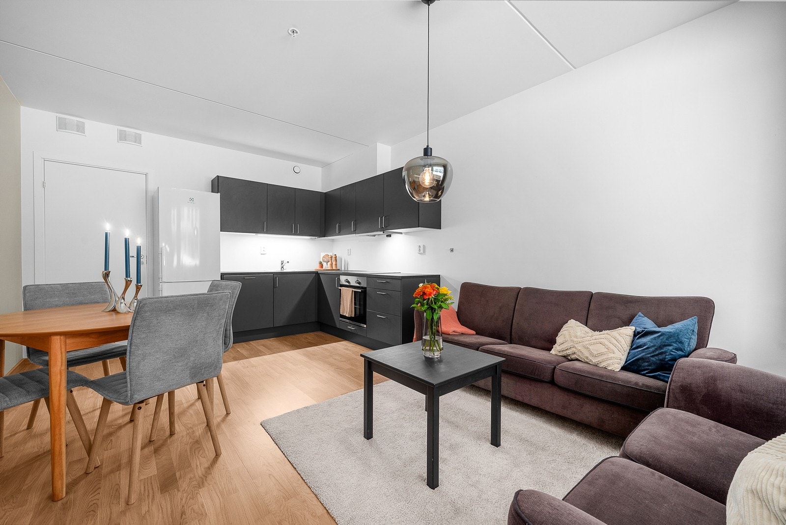 Åpen stue- og kjøkkenløsning. Pent kjøkken fra Norema med sorte fronter og en mørk benkeplate. Galleribilde