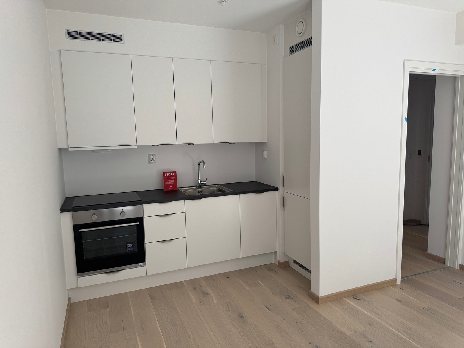 Pent og lyst kjøkken med integrerte hvitevarer. Galleribilde