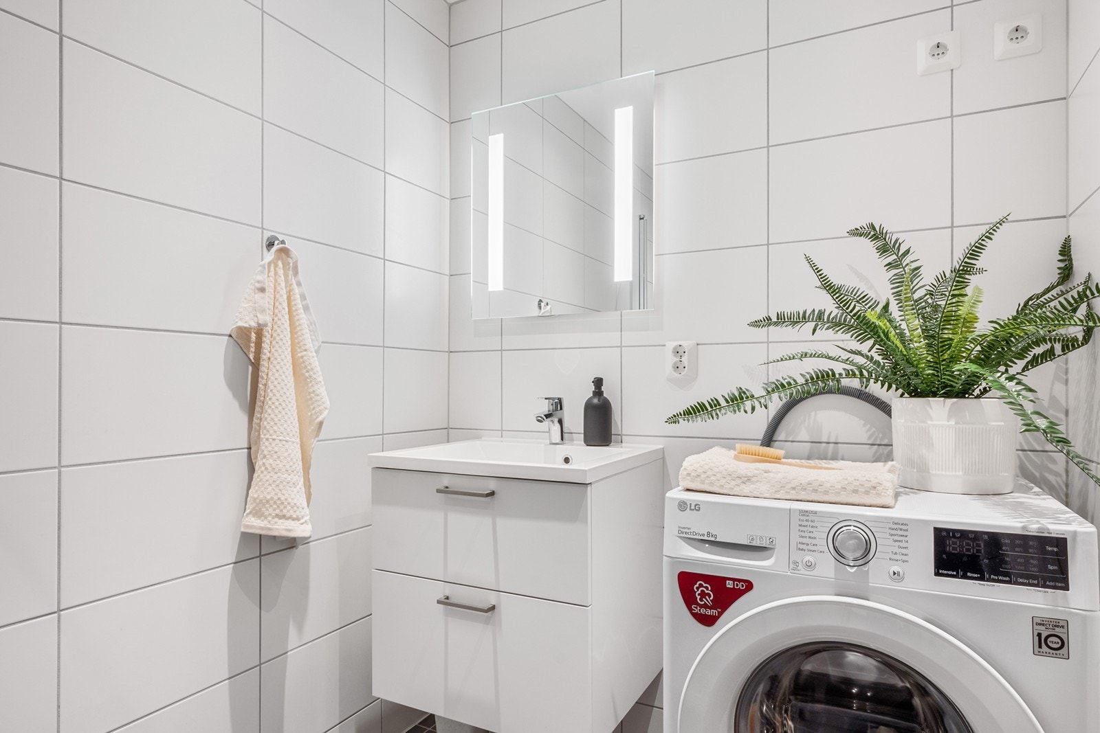 Badet fremstår delikat og tidløst med flislagte overflater, vannbåren gulvvarme og downlights. Galleribilde