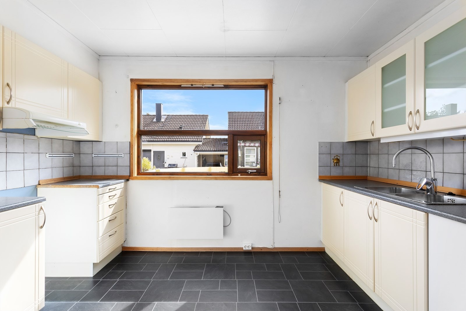 Romslig, separat kjøkken med flis på gulv, og flis på vegg over laminat benkeplate Galleribilde