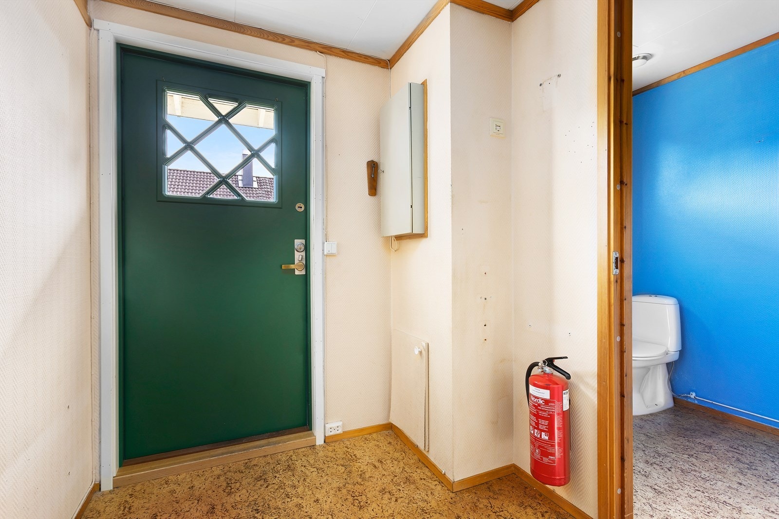 Romslig entré med belegg på gulv, malte overflater på vegger og malte plater i himling. Sikringsskap og stoppekran er plassert i entréen Galleribilde