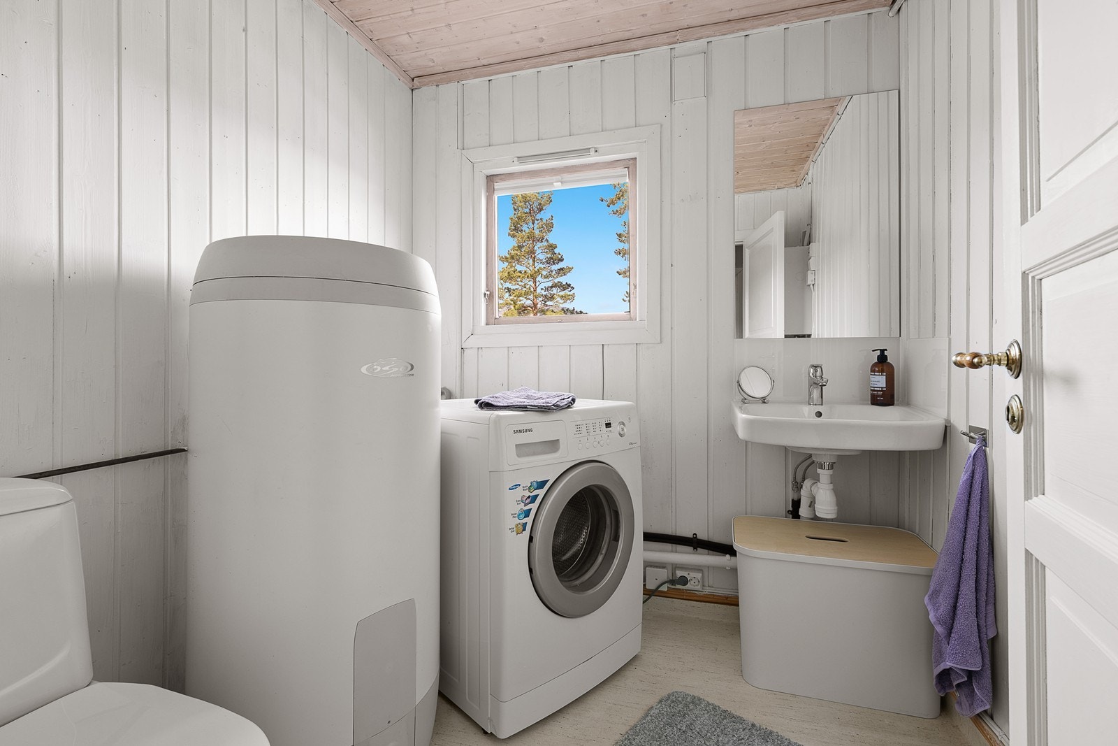 På vaskerommet er det oppsett for vaskemaskin, varmtvannstank. enkel servant, og toalett. Galleribilde