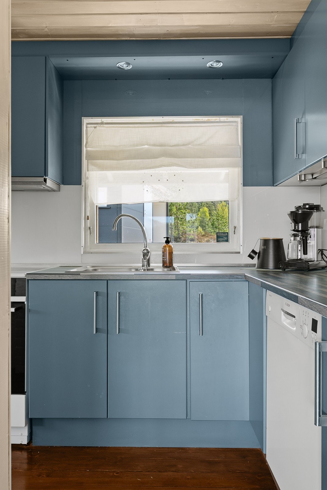 Oppvaskkummen i rustfritt stål er plassert ved et vindu som slipper inn rikelig med naturlig lys. Galleribilde